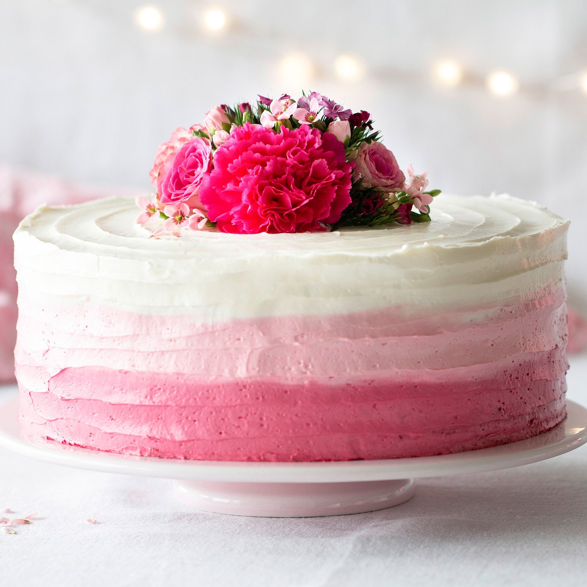Runde Ombre Torte in Pink mit frischen Blüten